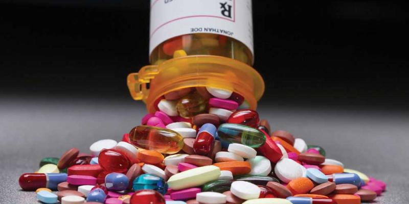 A pile of medicine pouring out of a prescription bottle
