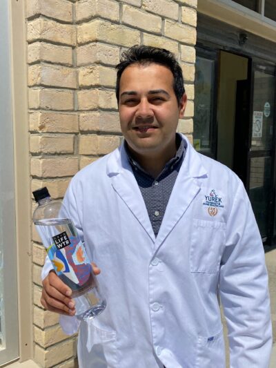 Pharmacist Vishal holds a bottle of water to stay hydrated.