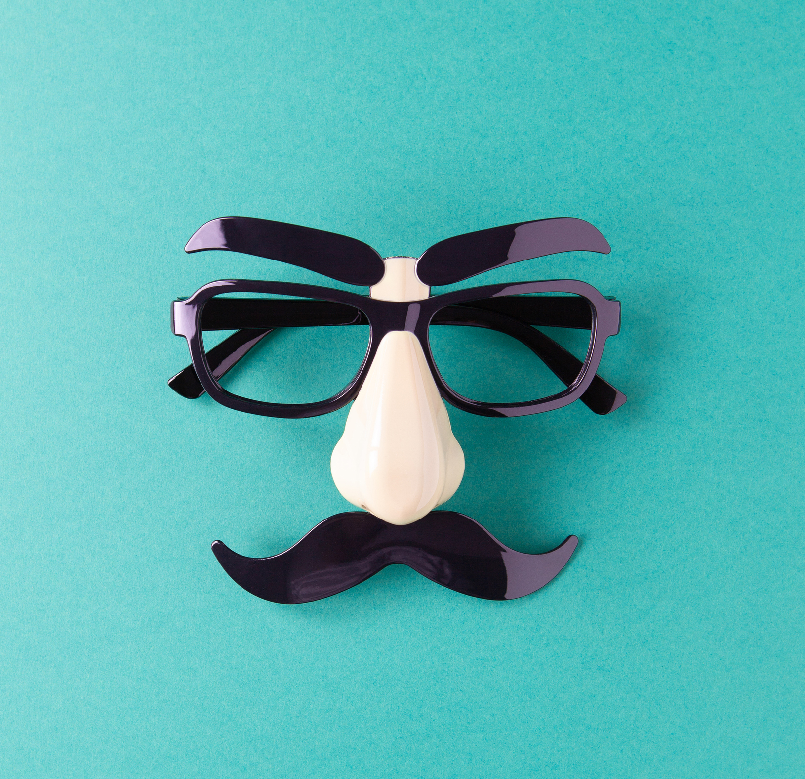 Representation of Movember using glasses, nose, and moustache on solid background.